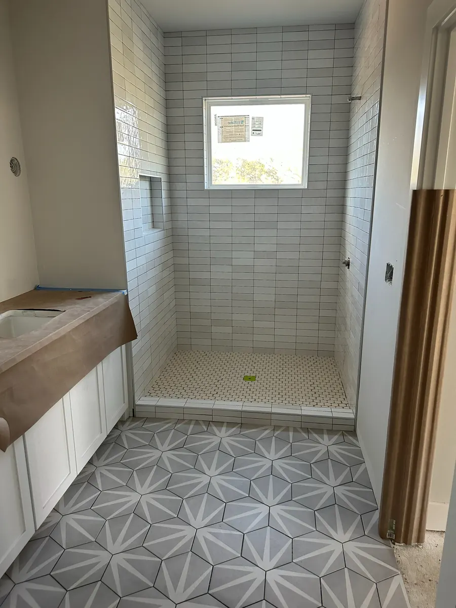 Walk-in shower tile and bathroom vanity under construction